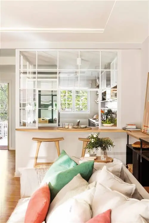 Кухня полуоткрыта в гостиную со стеклянным ограждением.