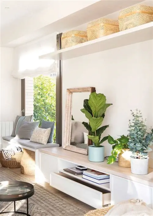 Небольшая гостиная с низким тумбой под телевизор и нестандартной скамейкой.