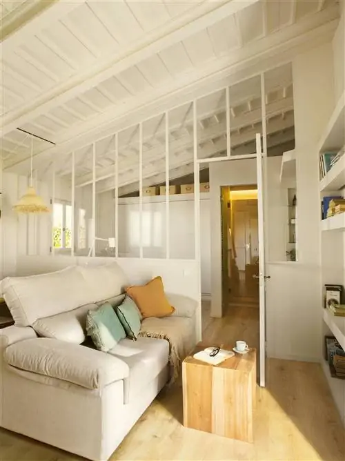 Мансардное помещение со стеклянным ограждением, которое отделяет его от спальни.