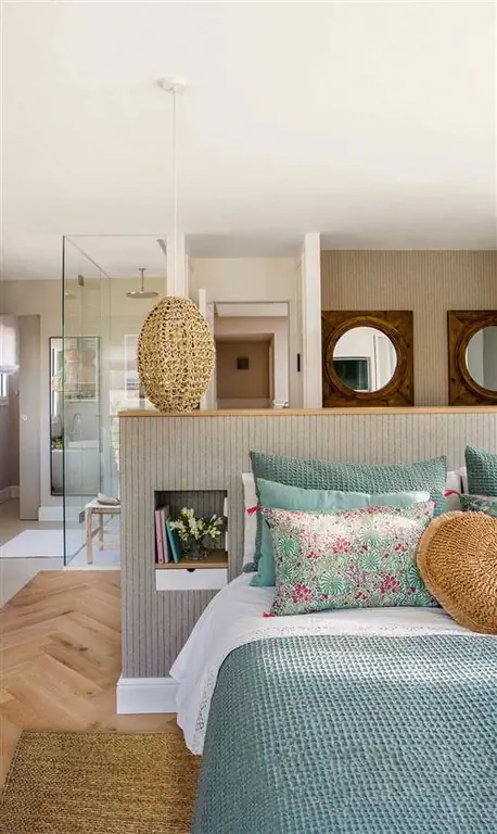 Спальня с ванной комнатой с изголовьем стены, которая разделяет ванную комнату и гардеробную.