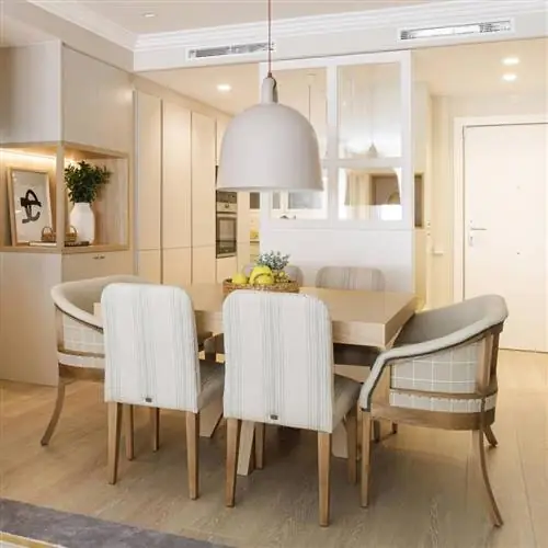 Гостиная с деревянным столом, мягкими стульями и кухня со стеклянным ограждением, проект Пиа Капдевила