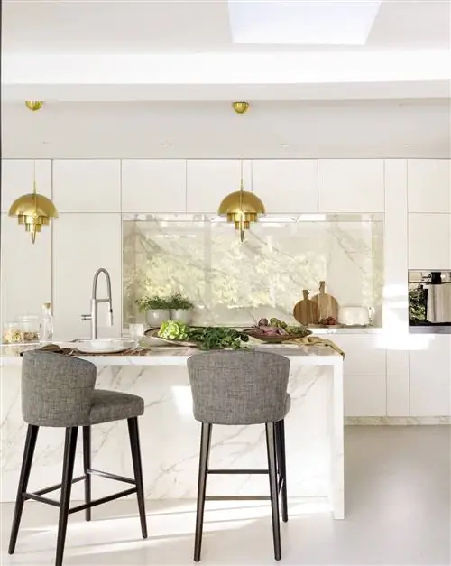 Белая кухня с фартуком Neolith и островной столешницей.