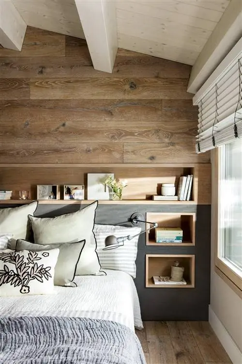 Дубовое изголовье в спальне с нишами, которые служат полками и прикроватными тумбочками.