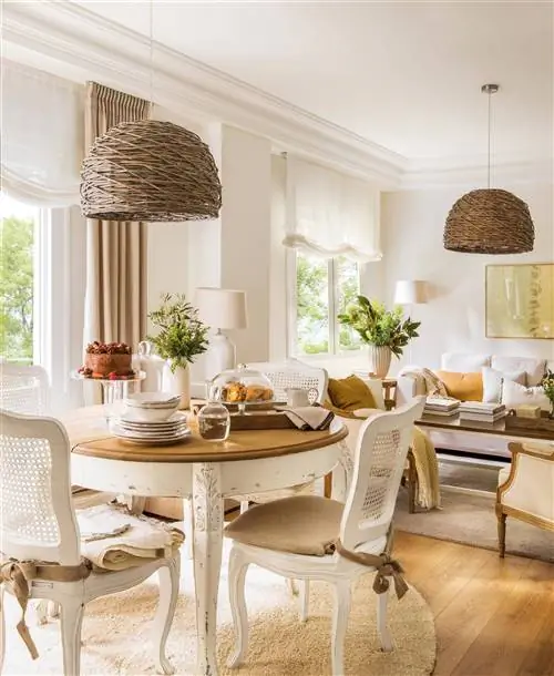 Столовая с круглым столом и потолочным светильником. На заднем плане гостиная.