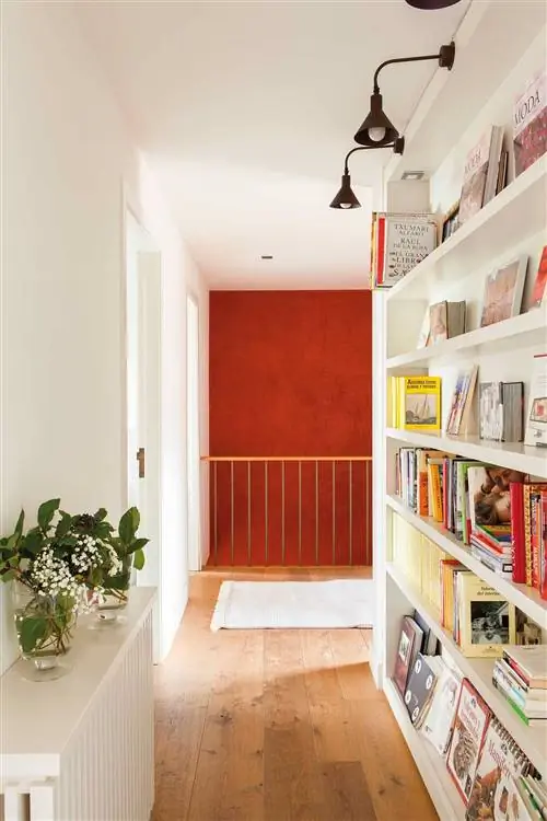 Книжный шкаф в коридоре с большим количеством места для хранения книг.