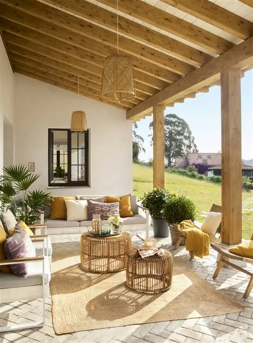 Веранда с двумя диванами, двумя креслами и декоративными элементами из волокна и дерева.