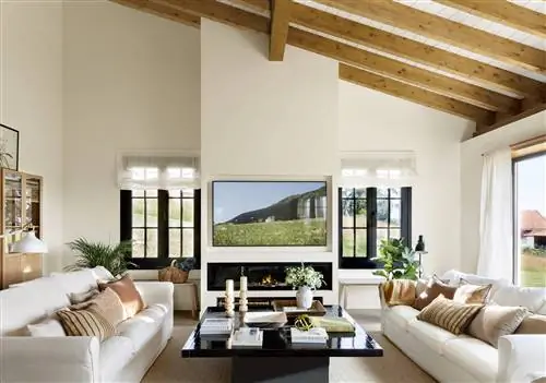 Гостиная с белыми диванами, черным журнальным столиком и современным камином с телевизором.