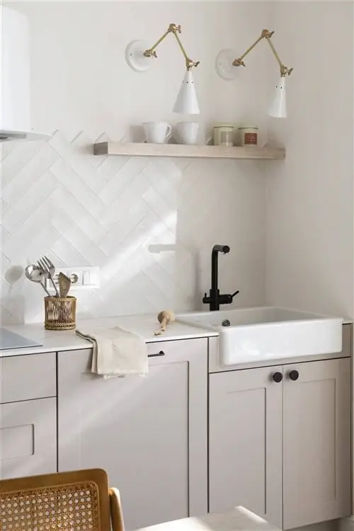 Кухня с белыми кафельными стенами.