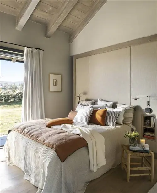 Спальня с покрытой стеной изголовья.