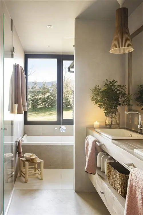 Ванная комната с подвесной деревянной мебелью и ванной под окном.