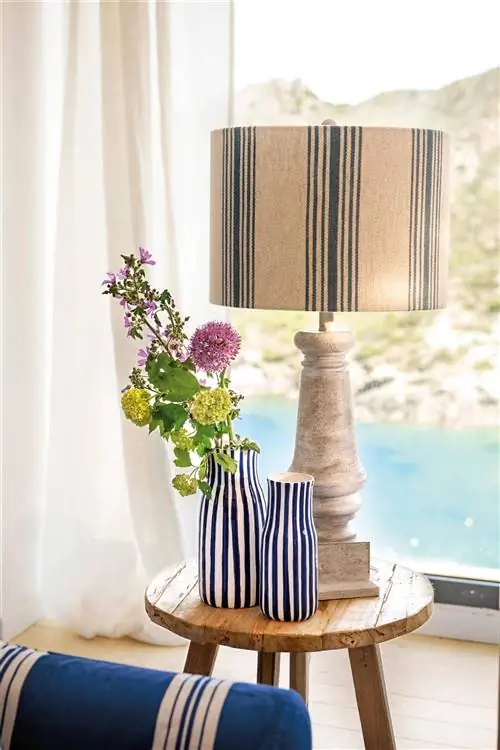 Пара больших декоративных ваз с голубыми полосками на приставном столике.