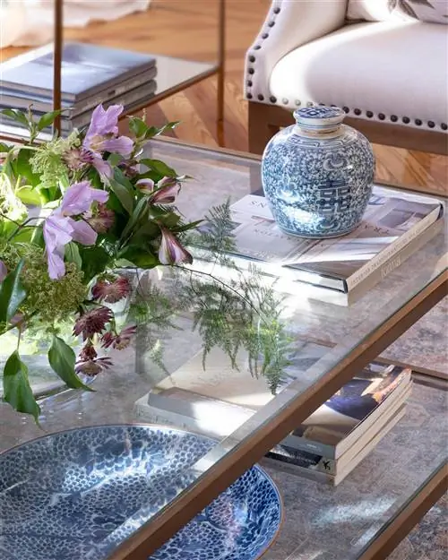 Стеклянный журнальный столик, украшенный синим тибором модели Qing от El Corte Inglés.