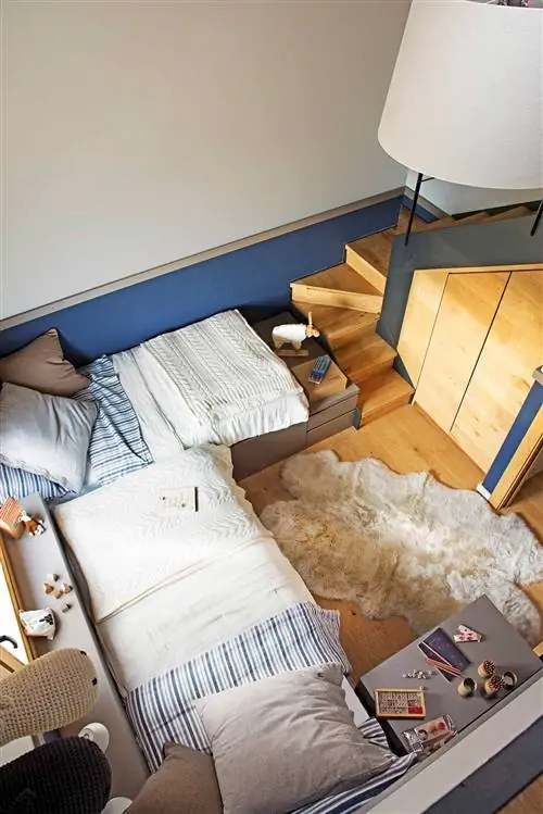 Небольшая комната с двумя кроватями, расположенными под углом