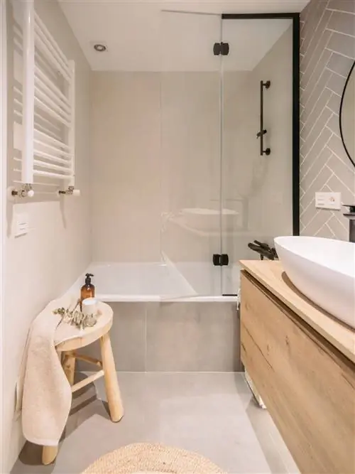 Ванная комната с ванной и деревянной мебелью.