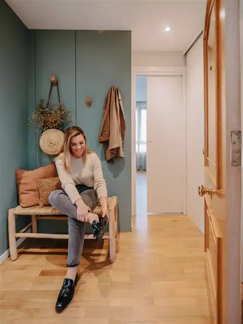 Холл с зелеными стенами и скамьей из дерева и волокна.