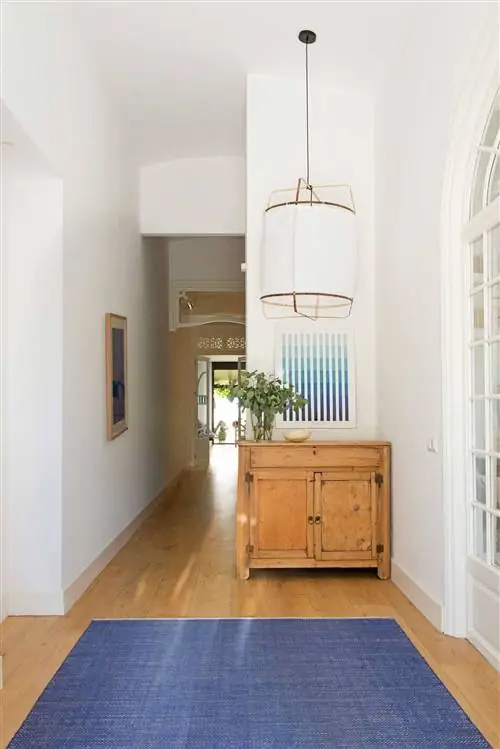 Зал с деревянным буфетом и синим ковром.