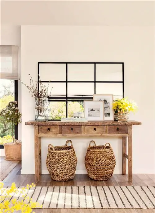 Зал с деревянной консолью, сетчатым зеркалом и корзинами.