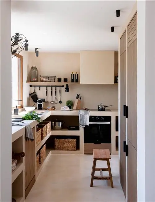 Встроенная кухня облицована бежевым микроцементом.