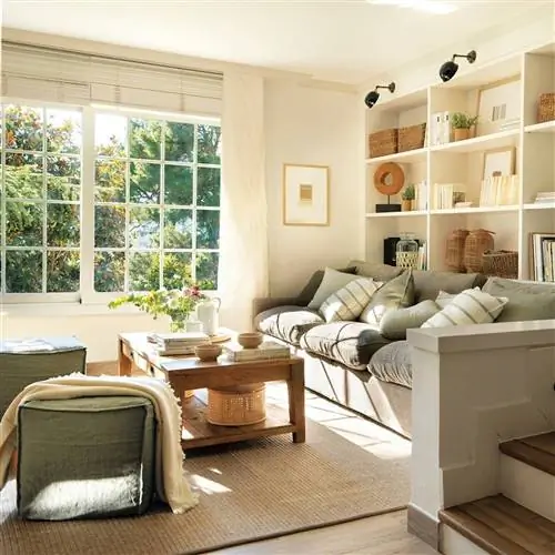 Гостиная с большими окнами с видом на сад и изготовленным на заказ книжным шкафом