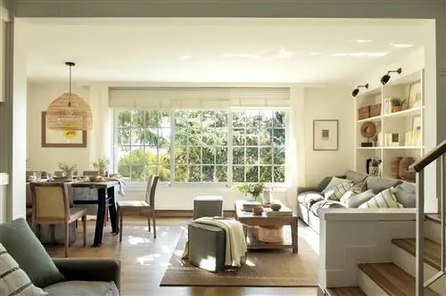 Гостиная с большими окнами и нестандартным книжным шкафом.