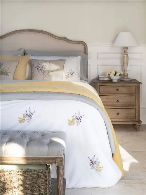 Спальня с классическим изголовьем на деревянном каркасе.