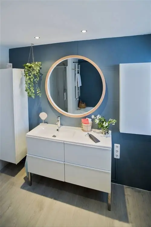 современная ванная комната с белым шкафом и синей стеной