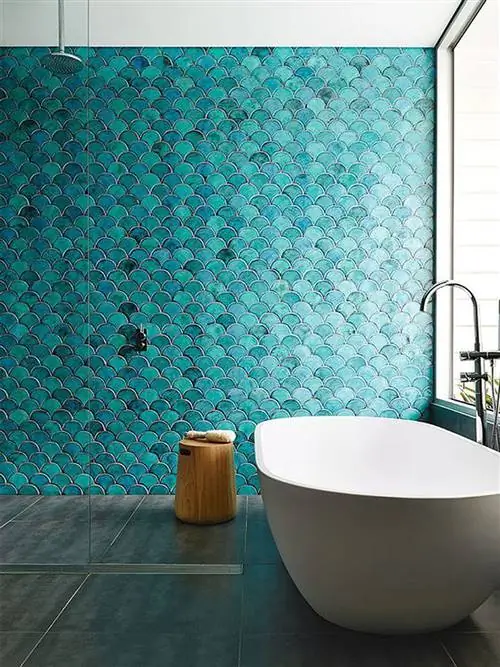 ванная комната с синей плиткой и современной отдельно стоящей ванной