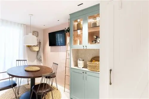 деревенский офис с ковром из натурального волокна и пастельно-зеленым шкафом с подсветкой