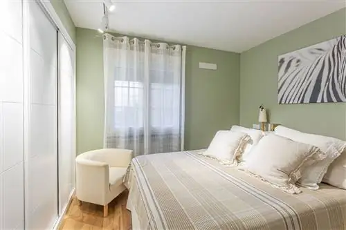 спальня с зелеными стенами и встроенным шкафом с белыми раздвижными дверями