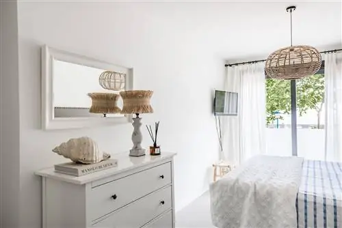 комод и зеркало в белой раме в спальне