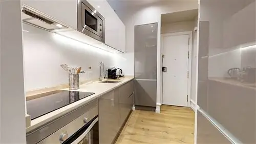 современная кухня с серыми лакированными шкафами и деревянным полом