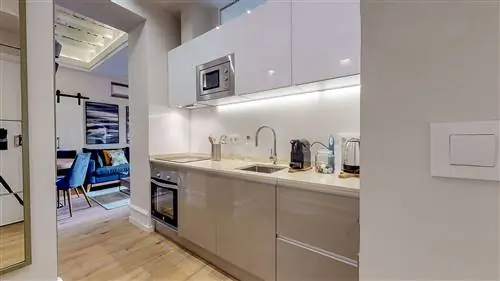 современная кухня с серыми лакированными шкафами и деревянным полом