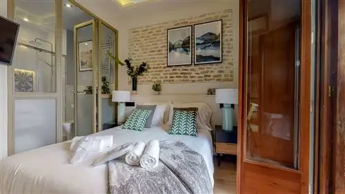 спальня с ванной комнатой со стеклянным ограждением