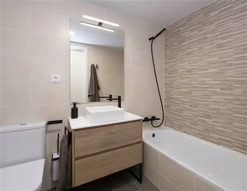 деревянная тумба и ванна, облицованная плиткой