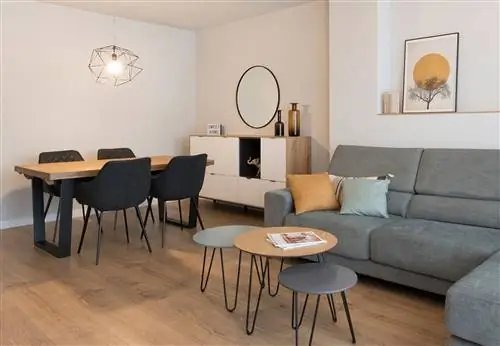 столовая с серым диваном, встроенными столами, деревянным обеденным столом и черными стульями