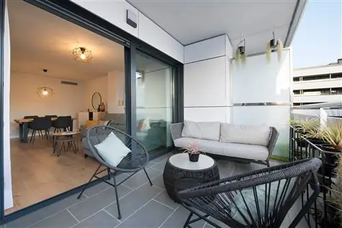 терраса с черными стульями акапулько, бежевым диваном и журнальным столиком из черного волокна