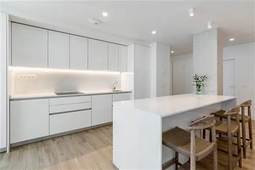 кухня в белом цвете с мраморным центральным островом рядом с цементной перегородкой