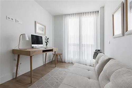 кабинет с деревянным столом и бежевым диваном-кроватью