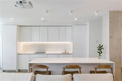 кухня в белом цвете с мраморным центральным островом рядом с цементной перегородкой