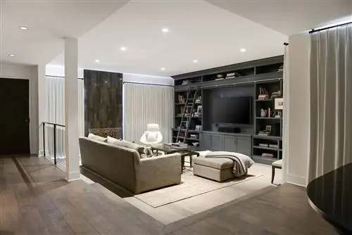 Гостиная с диваном и пуфом нейтрального цвета и библиотека с центральным местом для телевизора