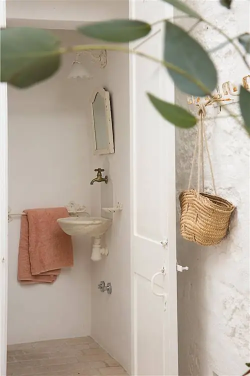маленькая белая ванная комната с мраморной раковиной