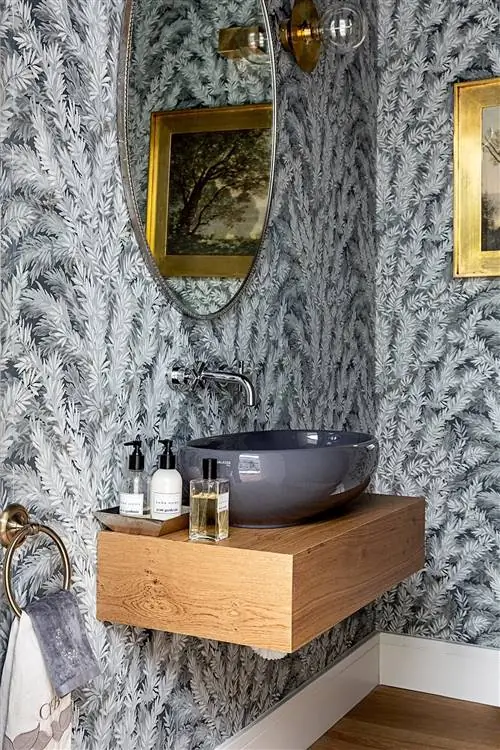 ванная комната с раковиной и серыми обоями и деревянной столешницей