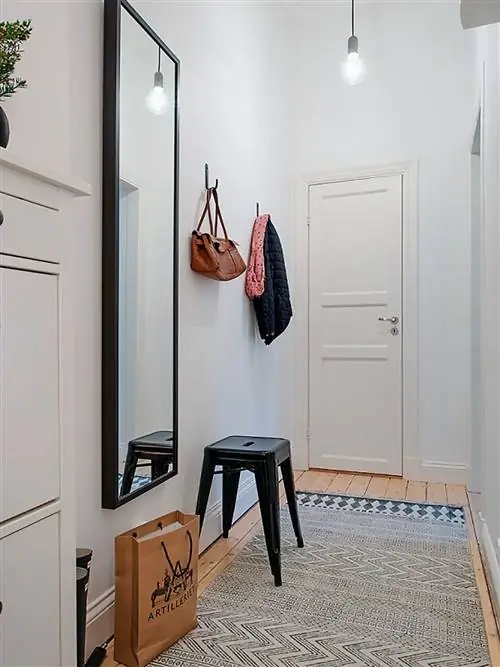 холл с черным зеркалом и табуреткой