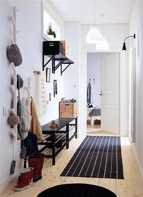 прихожая украшена скамьей для обуви и вешалкой для верхней одежды