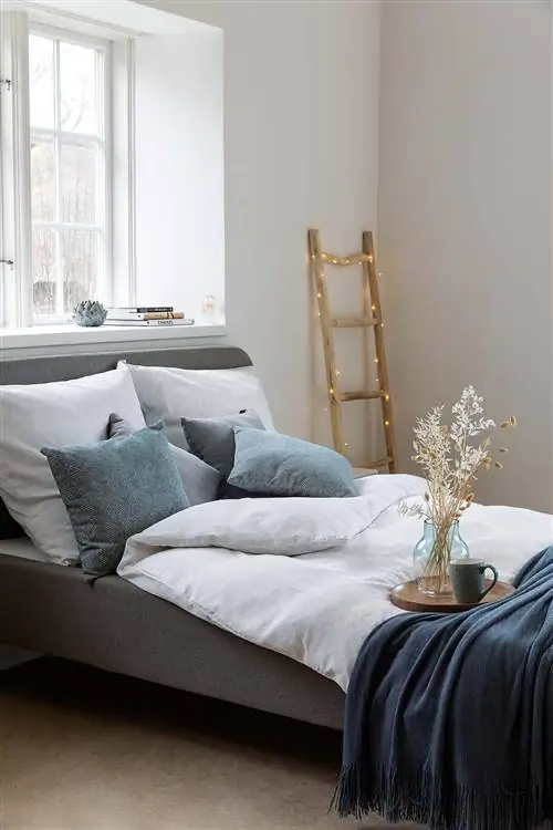 спальня с серой кроватью и белым одеялом