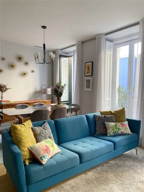 зеленовато-голубой диван с подушками в желтых тонах