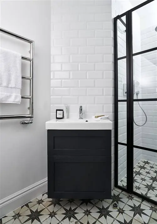 подвесная тумба под умывальник черного цвета и кафельный пол в форме звезды