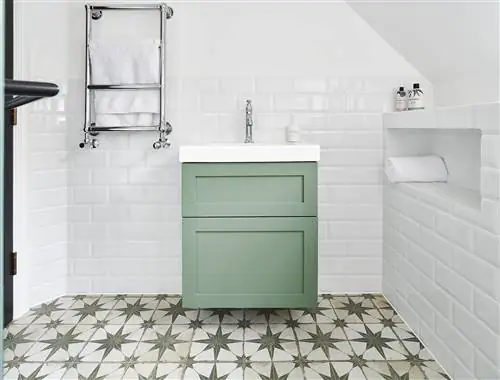 ванная комната с белыми стенами, выложенными плиткой метро, зеленой подвесной тумбой и энкаустической плиткой на полу