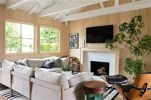 гостиная с камином, белыми ламинированными стенами, полом и потолком и выступающими балками