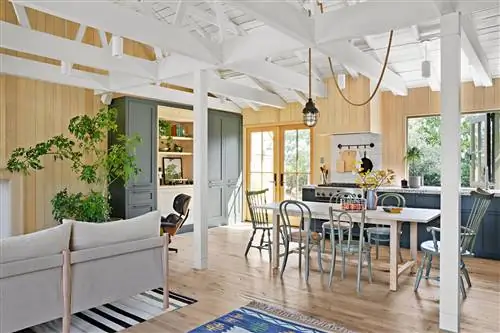 кухня-гостиная с камином, белыми ламинированными стенами, полом и потолком и выступающими балками